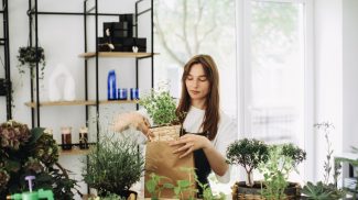 A young woman works in her flower shop. Small business concept.