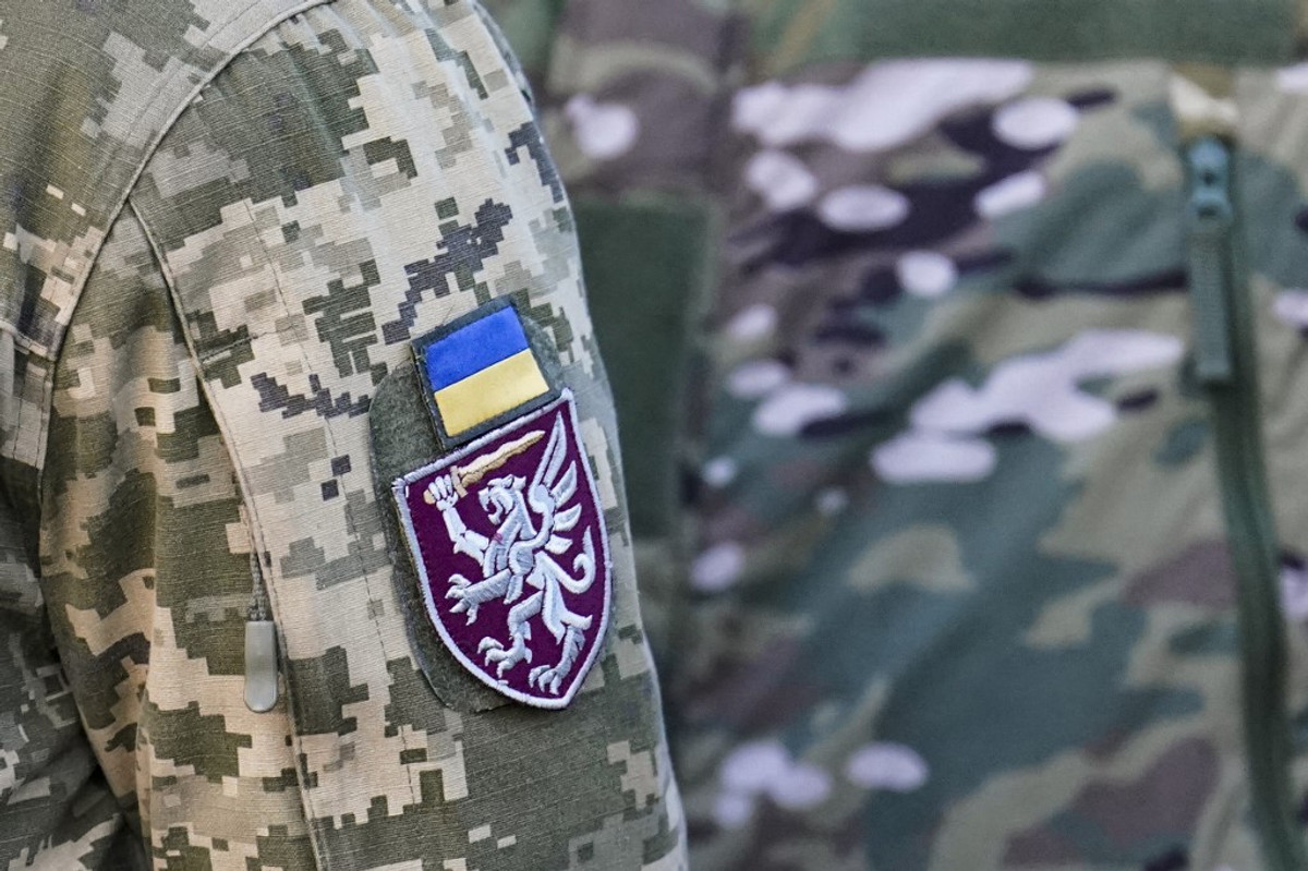 Іменник та прапор України на рукаві українського солдата.