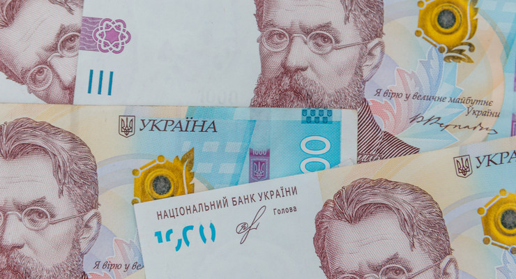 Українська гривня. На тлі банкнот номіналом тисяча гривень